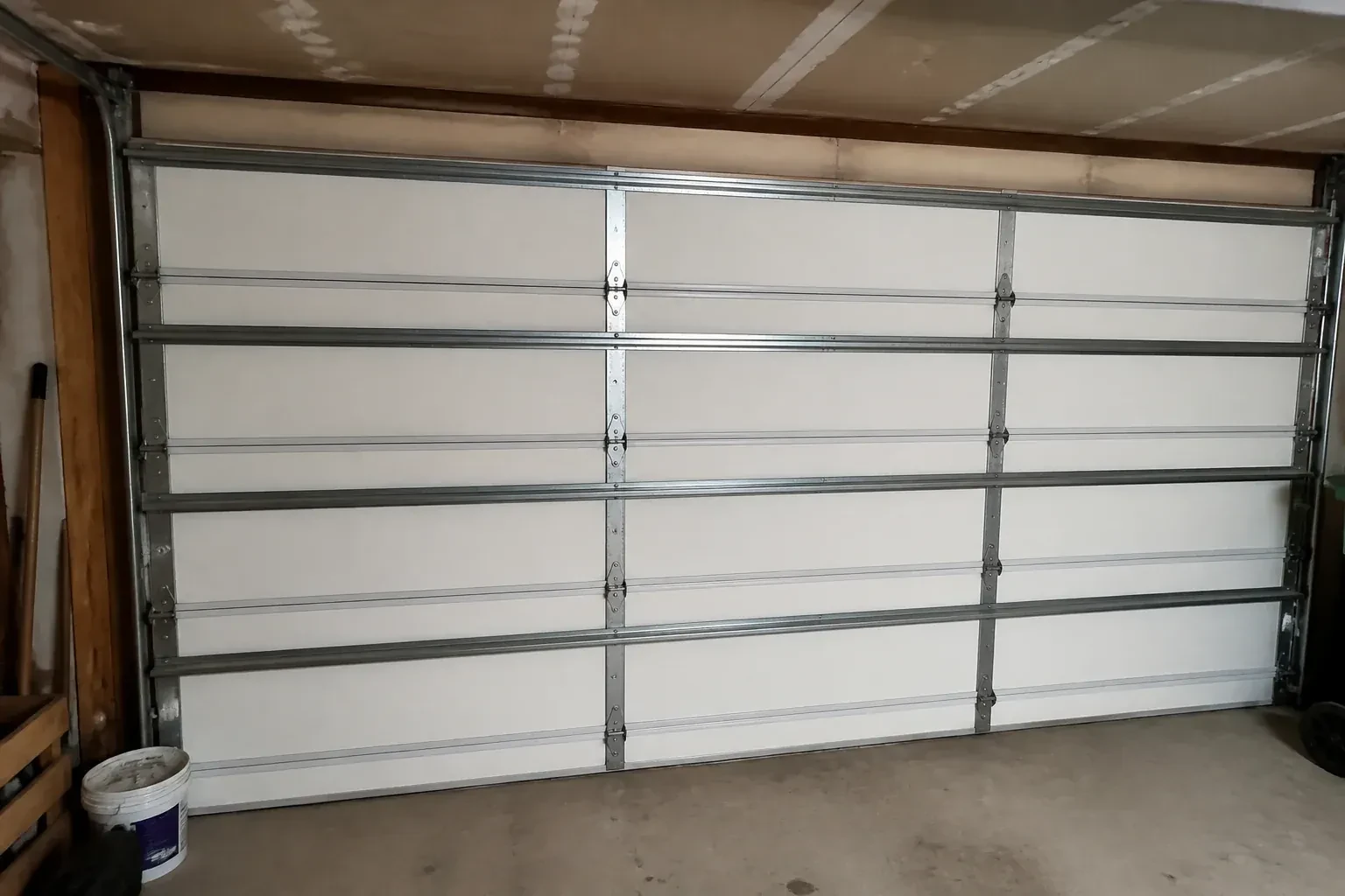 Interior of a closed sectional door with horizontal metal reinforcement struts. — Wind-Rated Garage Door Replacement, Oshawa